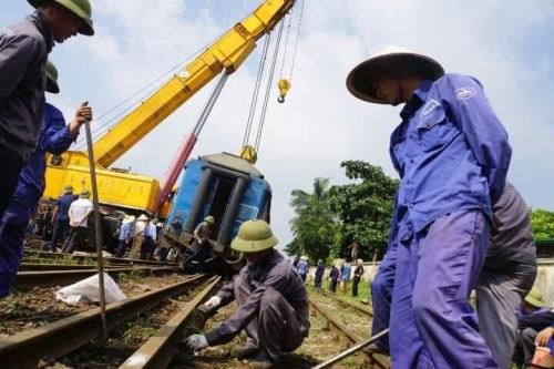 Ngành đường sắt đang khẩn trương khắc phục sự cố tàu SP2 trật bánh tại ga Yên Viên. Ảnh BNEWS