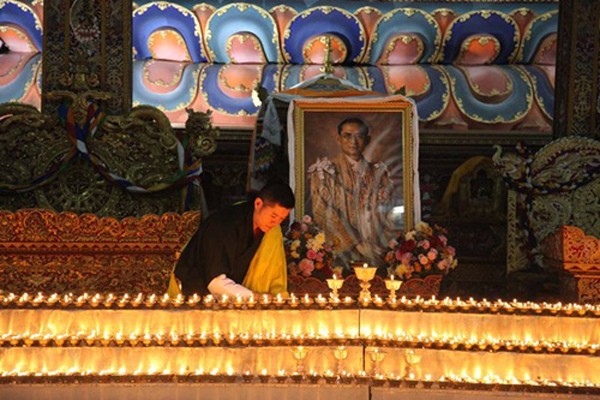 Quốc vương Bhutan Jigme Khesar Namgyel Wangchuck hôm qua thắp nến cạnh chân dung Quốc vương Thái Lan mới qua đời. Ảnh: Facebook