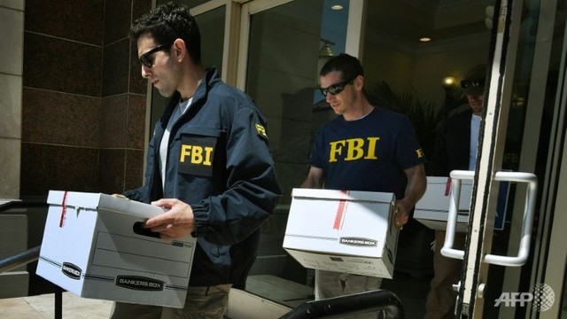 Các đặc vụ FBI thu giữ các tài liệu từ các văn phòng của Quỹ Đầu tư Nhập cư California tại California, Mỹ để phục vụ công tác điều tra (Ảnh: AFP)