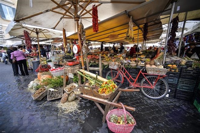 Người dân mua sắm tại một khu chợ ở Rome, Italy. (Ảnh: AFP/TTXVN)