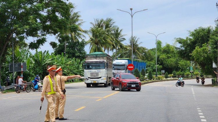 Lực lượng cảnh sát giao thông Công an tỉnh Quảng Ngãi thực hiện chỉ dẫn và phân luồng xe đi theo hướng mới thay thế hướng qua cầu Trà Khúc 2