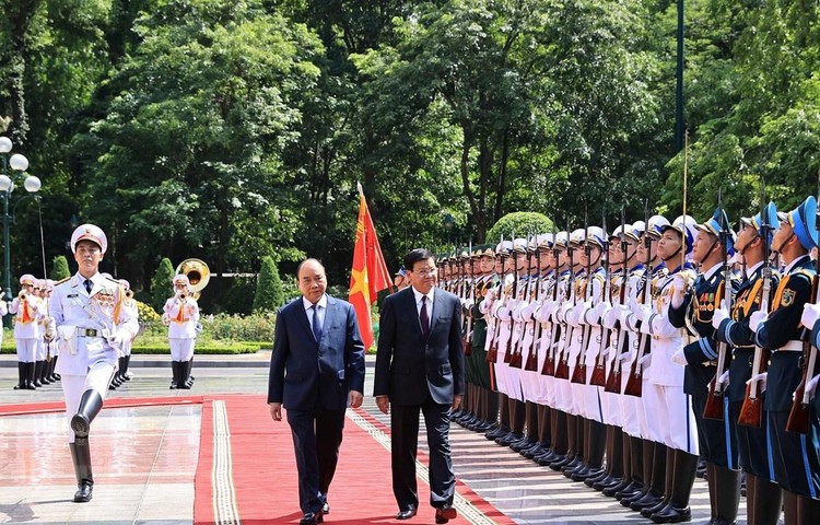 Chủ tịch nước Nguyễn Xuân Phúc và Tổng Bí thư Ban Chấp hành Trung ương Đảng Nhân dân Cách mạng Lào, Chủ tịch nước Cộng hòa Dân chủ Nhân dân Lào Thongloun Sisoulith duyệt Đội danh dự Quân dội nhân dân Việt Nam. Ảnh: Thống Nhất/TTXVN