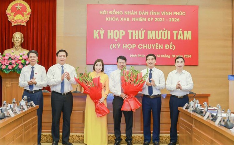 Ông Nguyễn Khắc Hiếu và bà Phùng Thị Kim Nga nhận hoa chúc mừng của các đại biểu