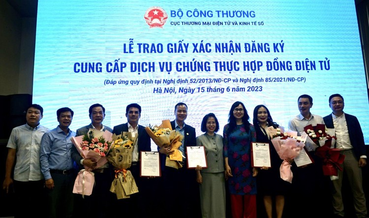 Lãnh đạo Cục Thương mại điện tử và Kinh tế số thuộc Bộ Công Thương cùng các đơn vị liên quan chụp ảnh cùng 5 đơn vị được trao giấy xác nhận đăng ký cung cấp dịch vụ chứng thực hợp đồng điện tử (ảnh: PT)