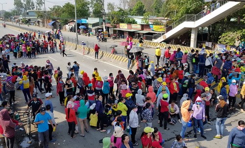 Công nhân chặn quốc lộ 1 cả hai chiều khiến tuyến đường này tê liệt nhiều giờ liền. Ảnh: Phước Tuấn.